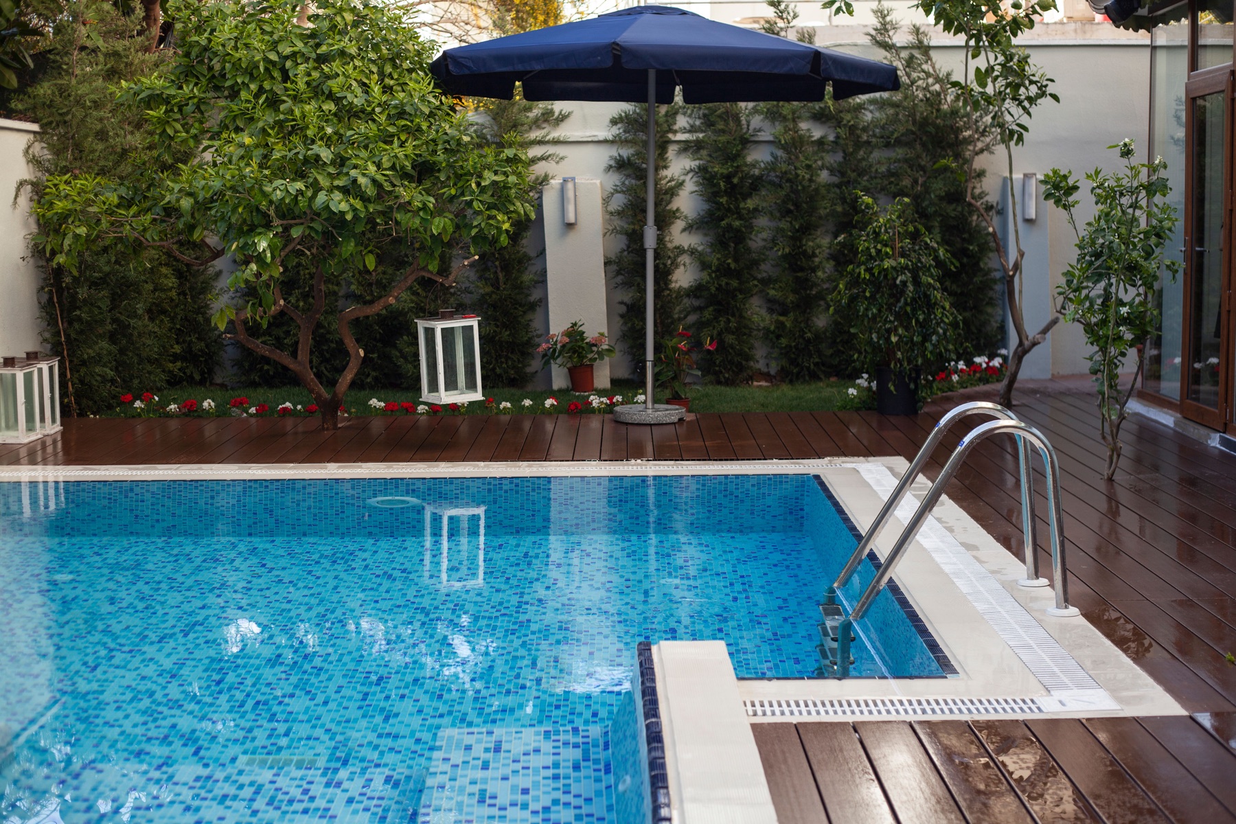 Sparkling residential backyard pool with navy umbrella